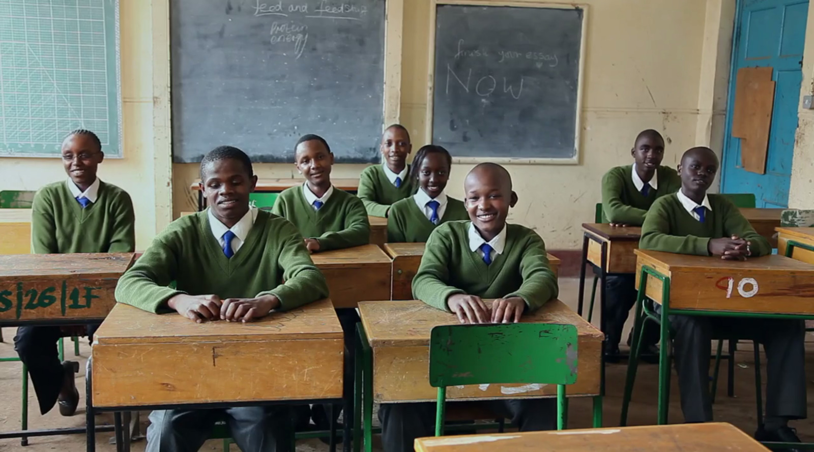 a group of men sitting at desks in a classroom