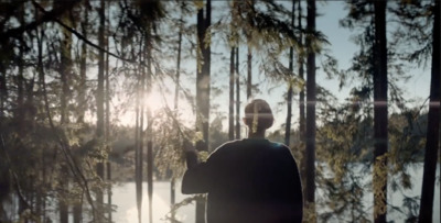 a man standing in front of a forest