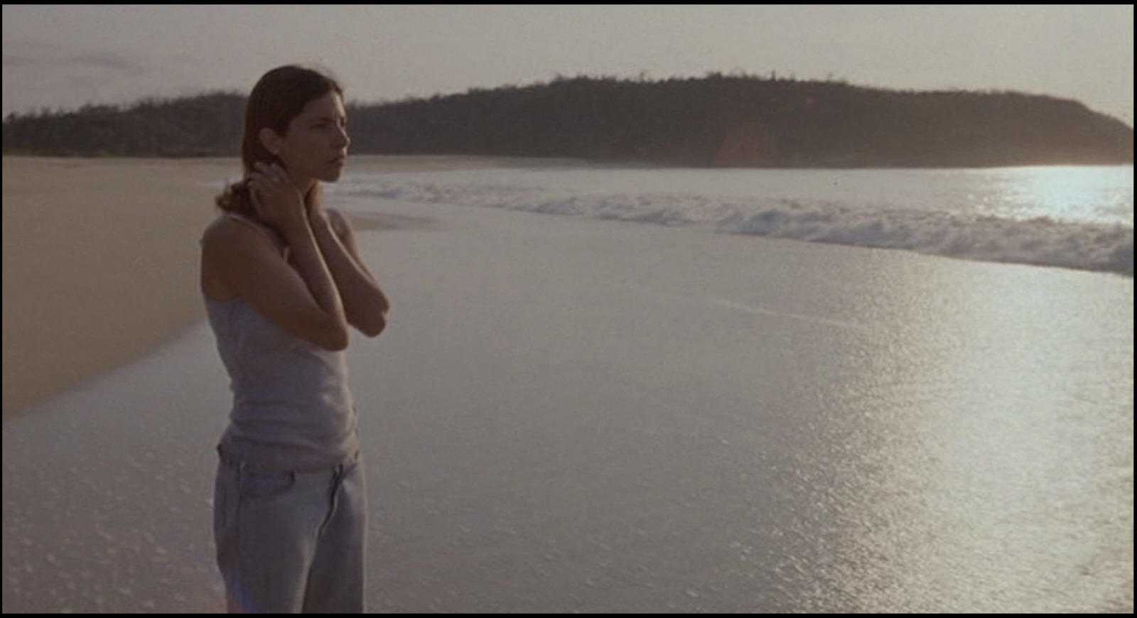 a woman standing on a beach next to the ocean