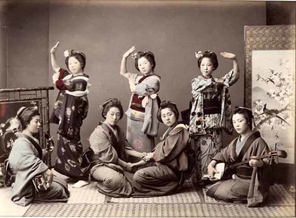 a group of women sitting on top of a bed