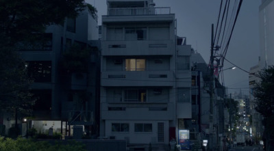 a city street at night with a building lit up