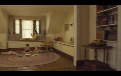 a couple of kids laying on a rug in a room