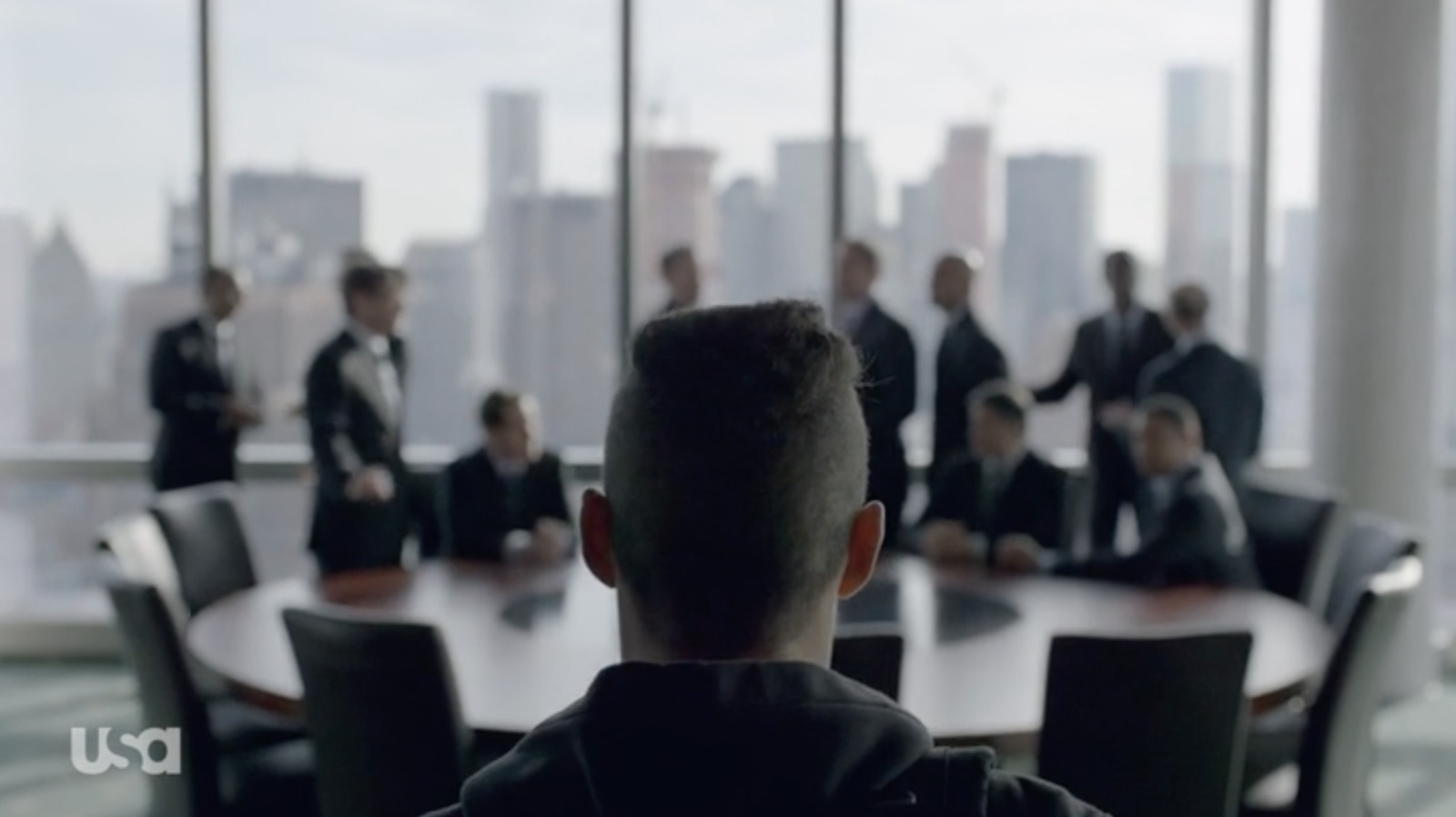 a man sitting at a table in front of a group of people