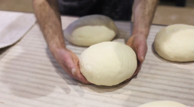 a man is kneading dough into a ball