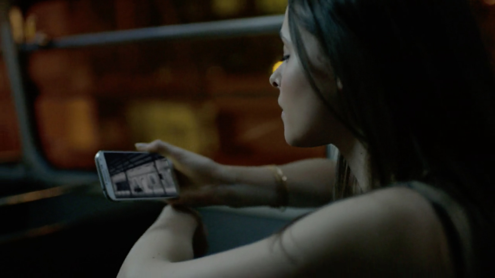 a woman sitting in a car holding a cell phone