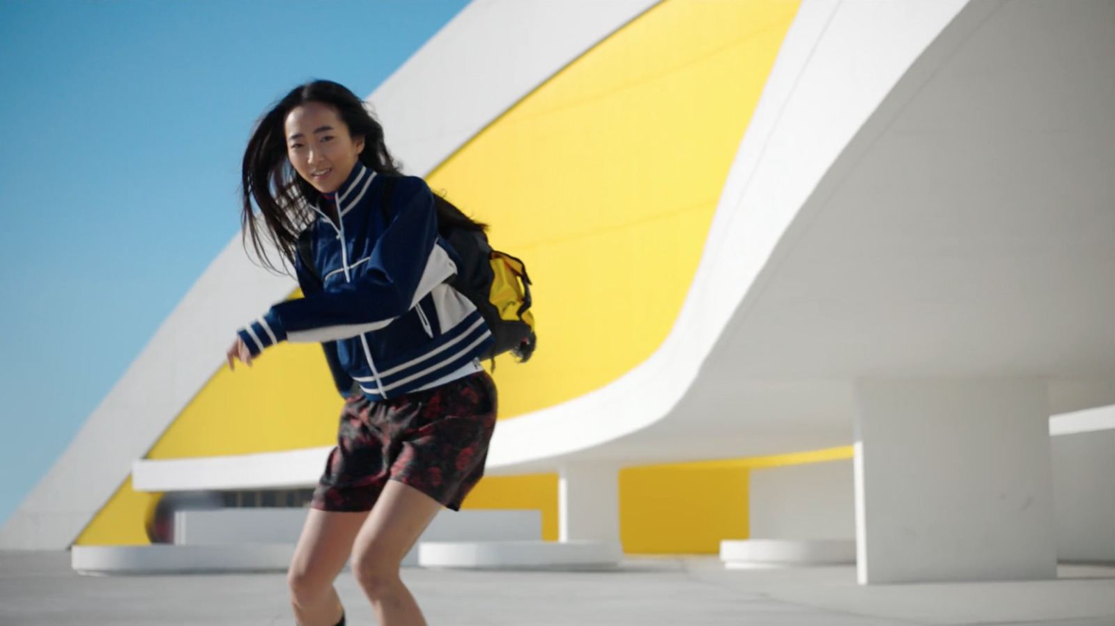 a woman riding a skateboard on top of a cement floor