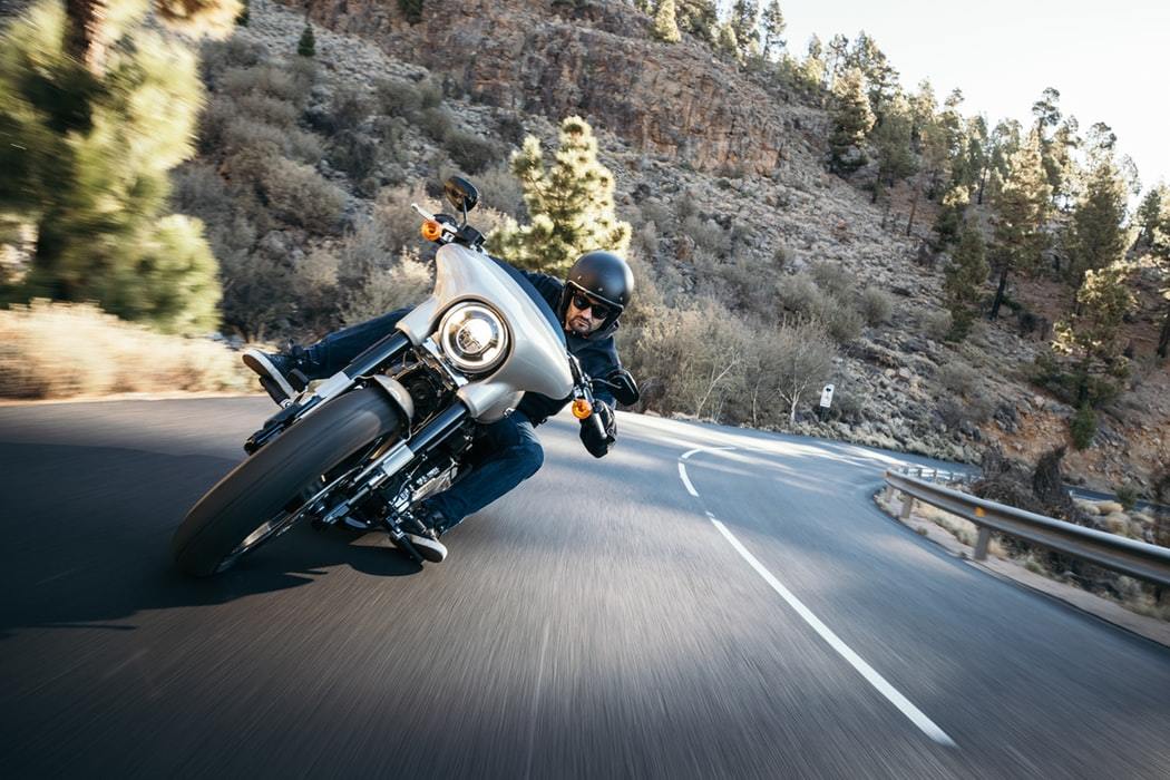 a man riding a motorcycle down a curvy road