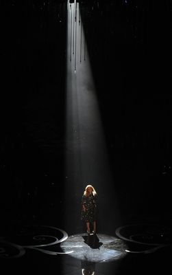 a woman standing on a stage in front of a spotlight