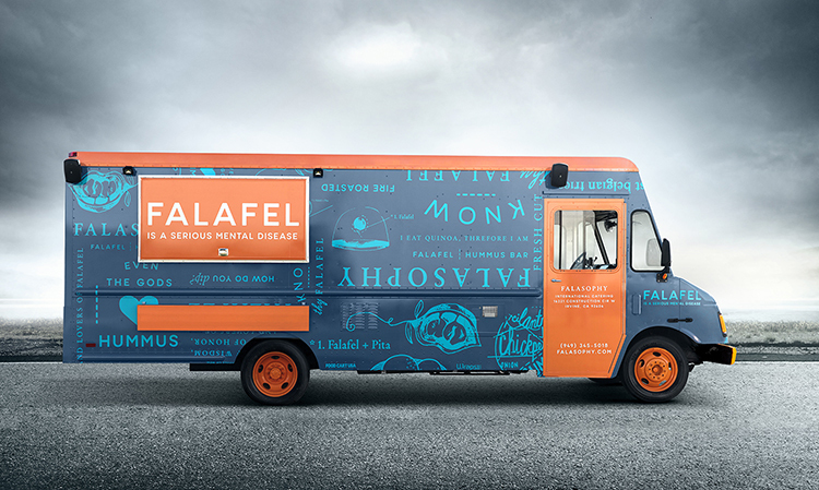 a blue and orange food truck parked on the side of the road