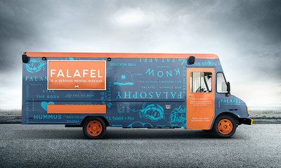 a blue and orange food truck parked on the side of the road