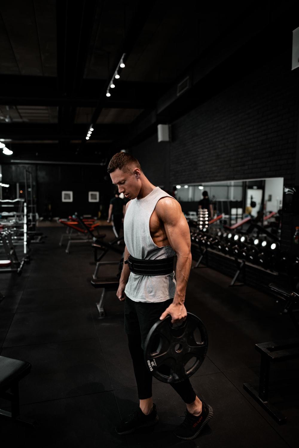 a man is holding a barbell in a gym