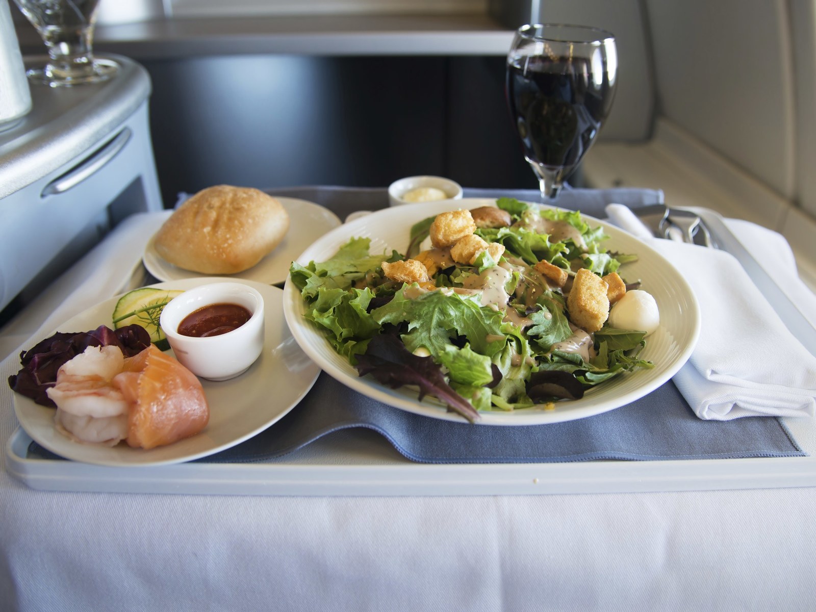 a plate of food and a glass of wine on a tray