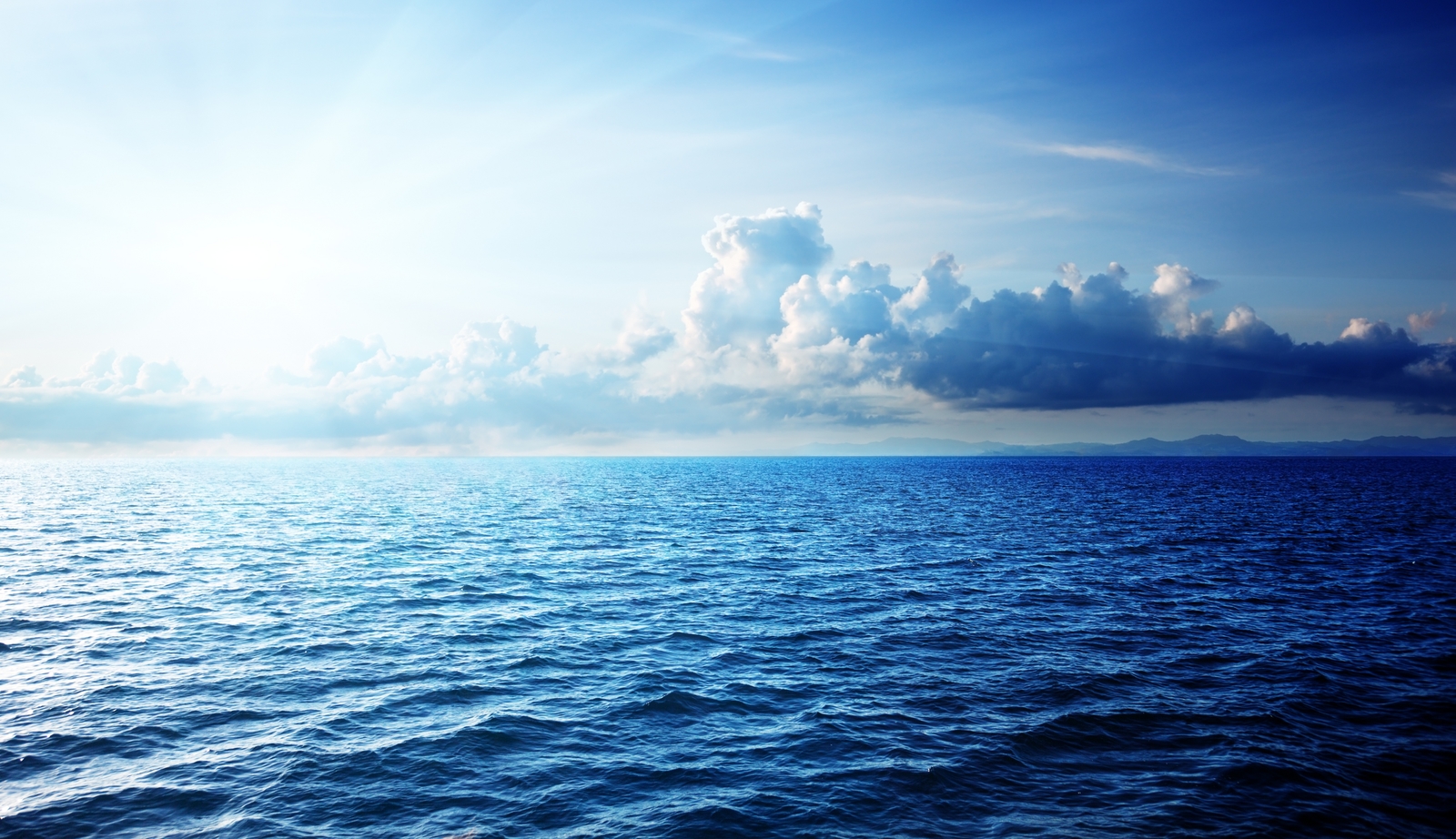 a large body of water under a cloudy sky