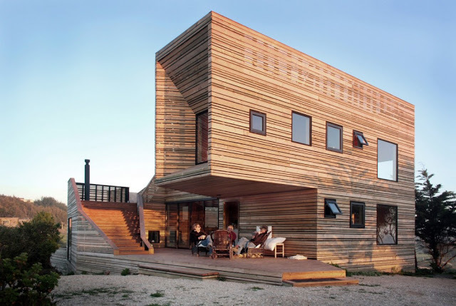 a couple of people sitting outside of a wooden building