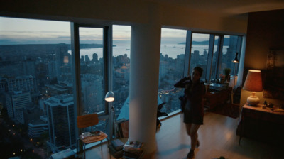 a woman standing in a living room next to a large window