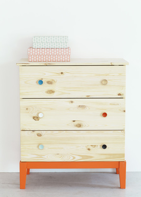 a wooden dresser with a stack of books on top of it