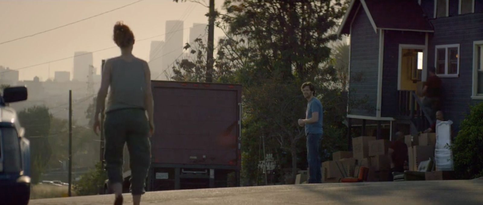 a woman walking down a street next to a truck