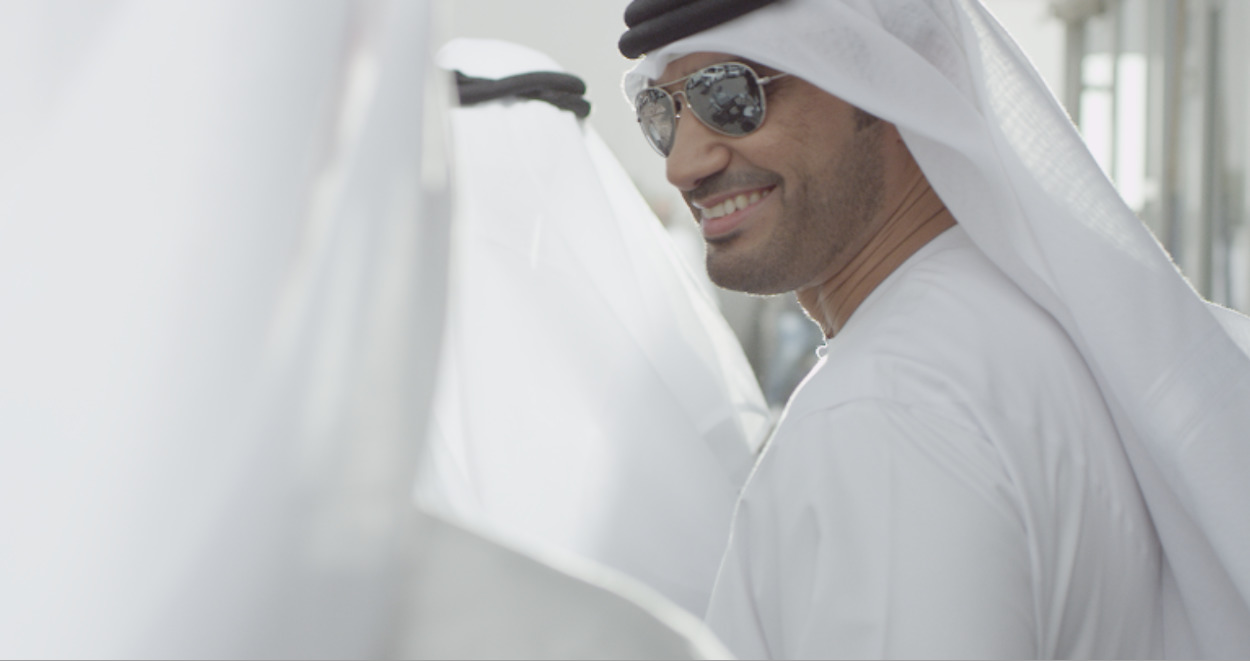 a man in a white outfit and sunglasses