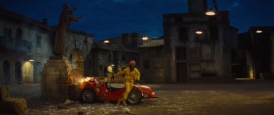 a man standing next to a red car on a street