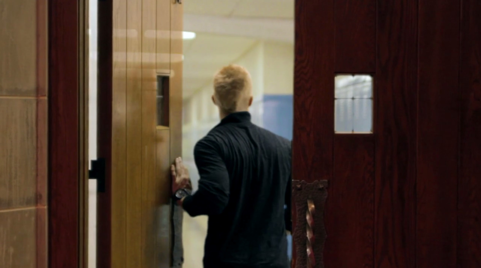 a man in a black shirt is opening a door