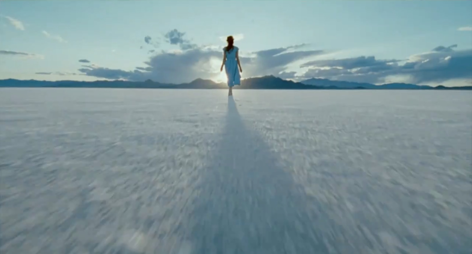 a woman walking across a large open field