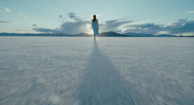 a woman walking across a large open field