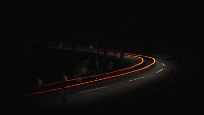 a car driving down a dark road at night