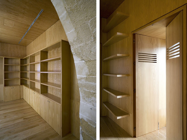 a room with wooden shelves and a stone wall