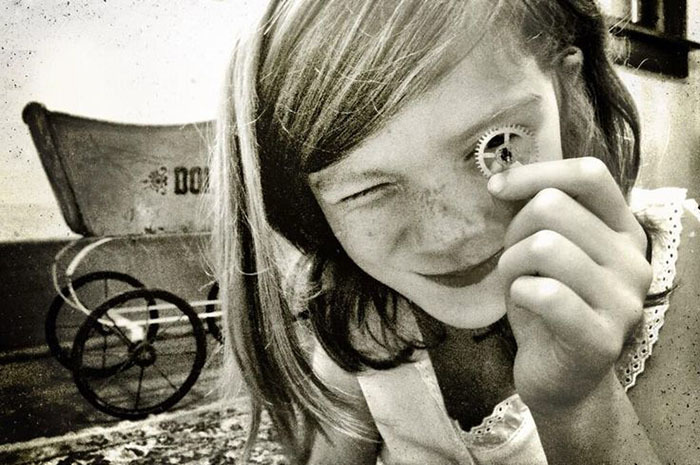 a young girl holding a piece of metal in her hand