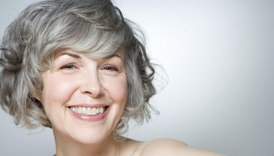 a woman with grey hair smiling for the camera