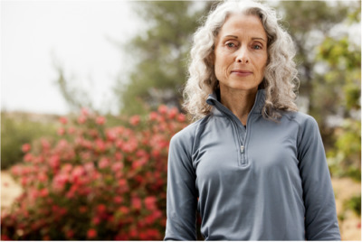 a woman standing in front of a bush