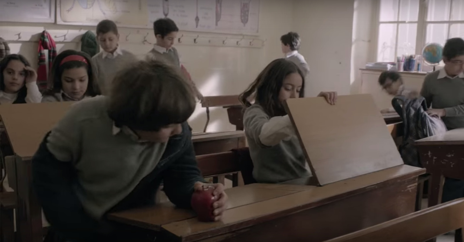 a group of children sitting at desks in a classroom