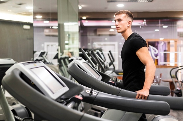 a man standing on a treadmill in a gym