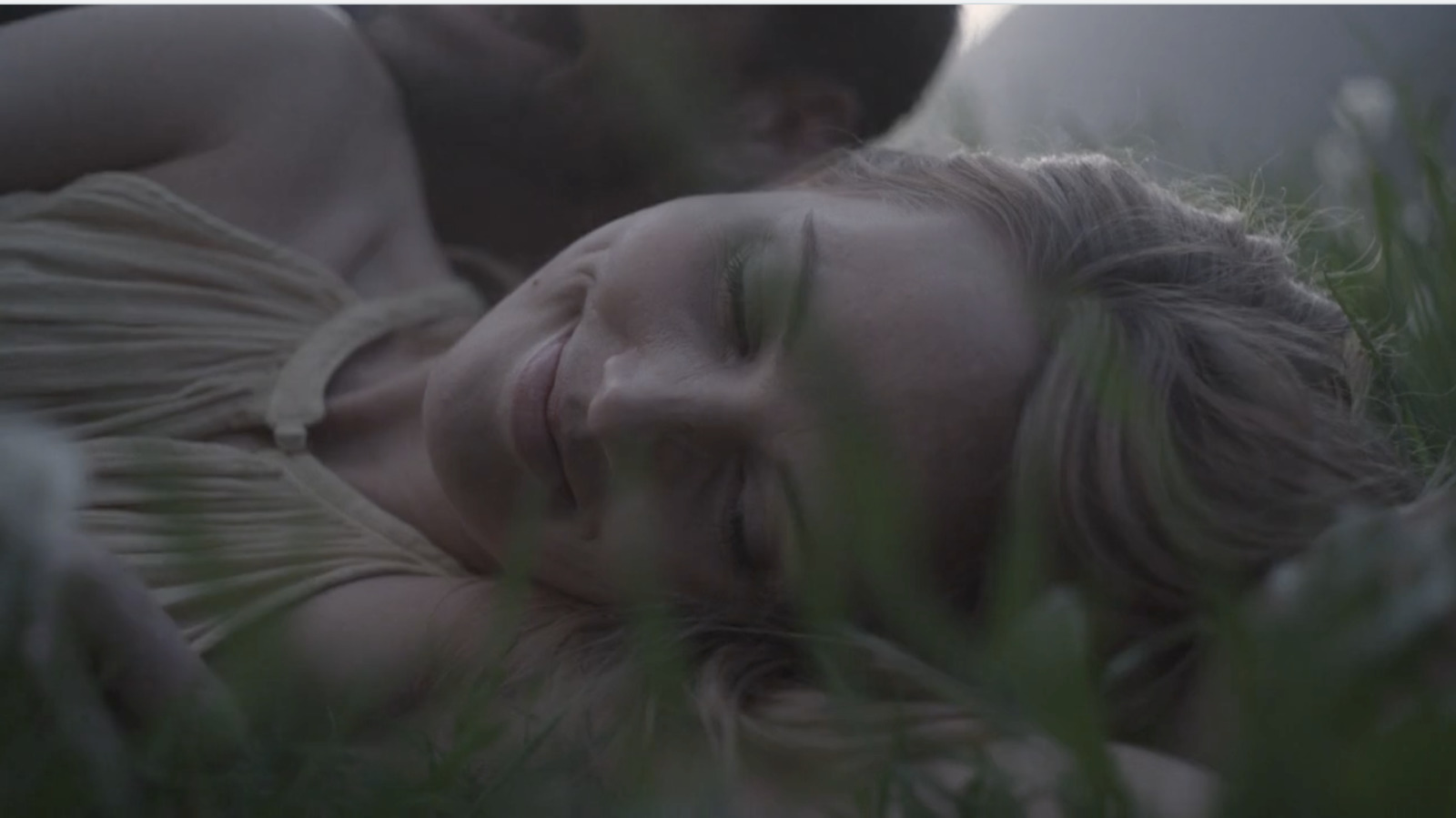 a man and a woman laying in the grass