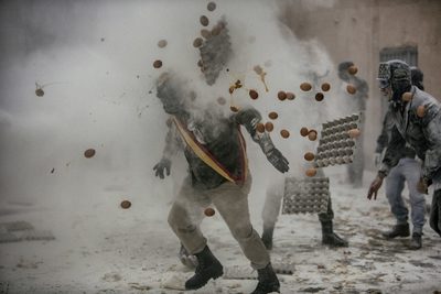 a group of people throwing oranges at each other