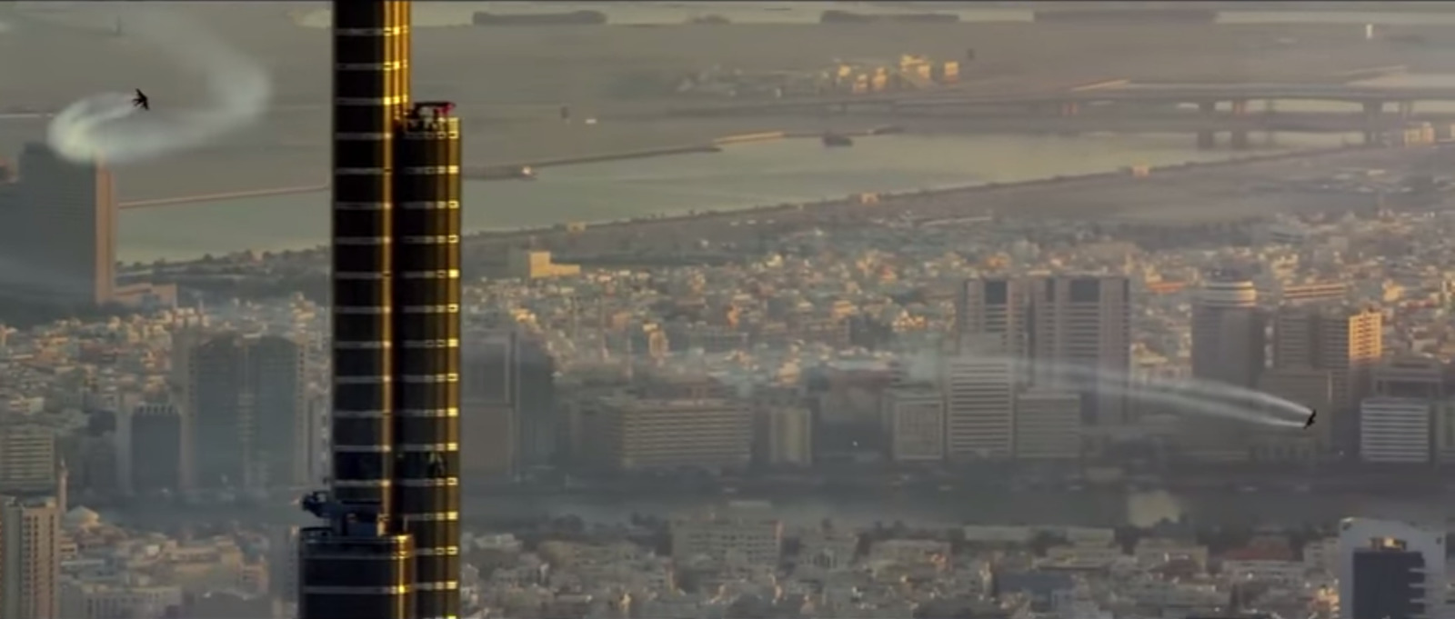 an aerial view of a city with a plane in the sky