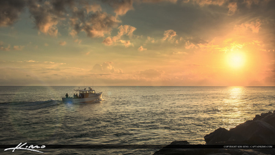 a boat sailing in the ocean at sunset