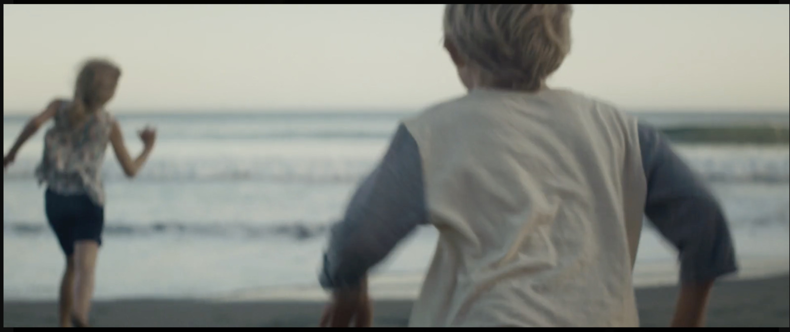 a blurry photo of a man and a woman walking on the beach