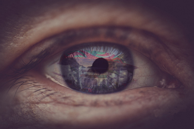 a close up of a person's eye with the reflection of a building in