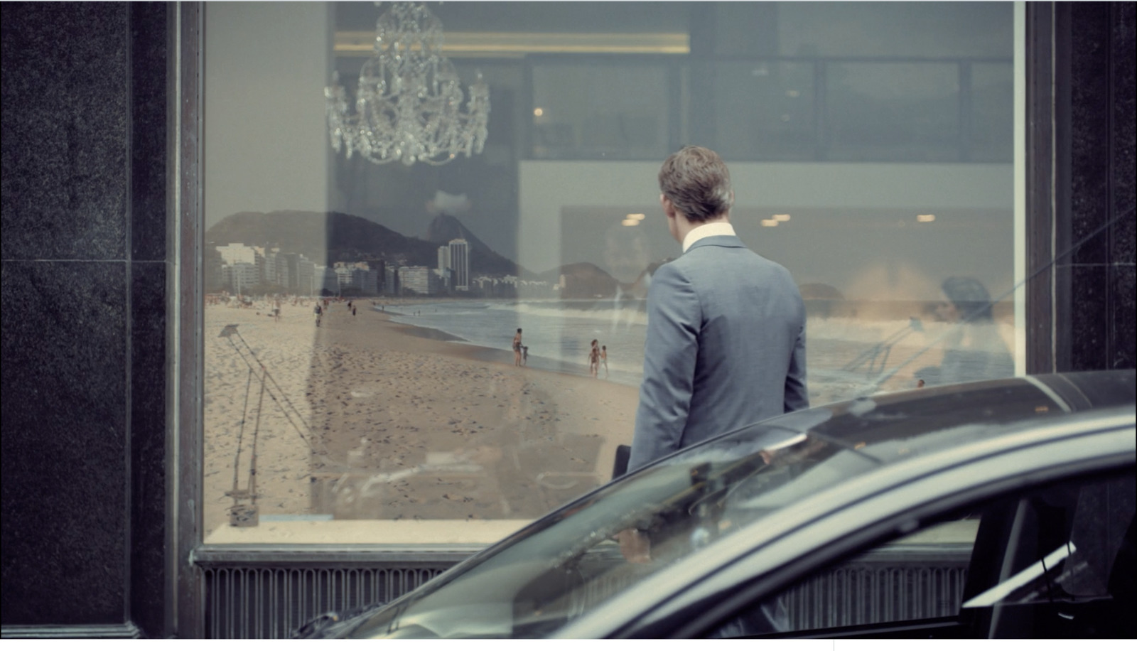 a man in a suit standing in front of a window