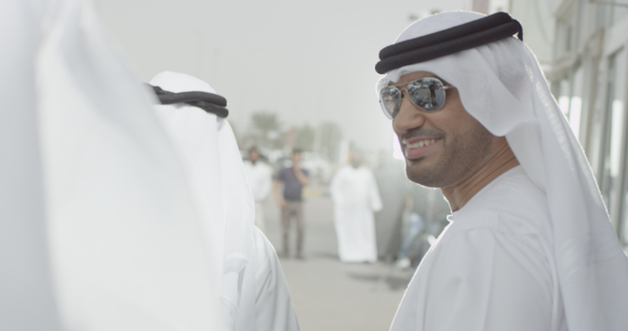 a man in a white outfit and sunglasses