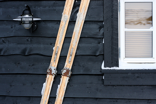 a pair of skis leaning against the side of a house