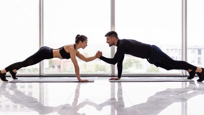 a man and a woman doing a handstand on a mat