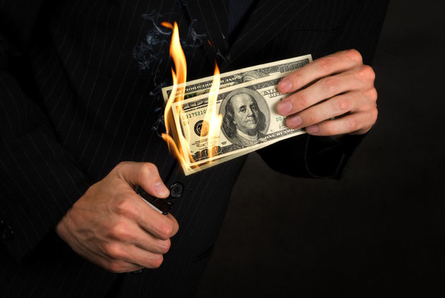 a man in a suit holding a bundle of money