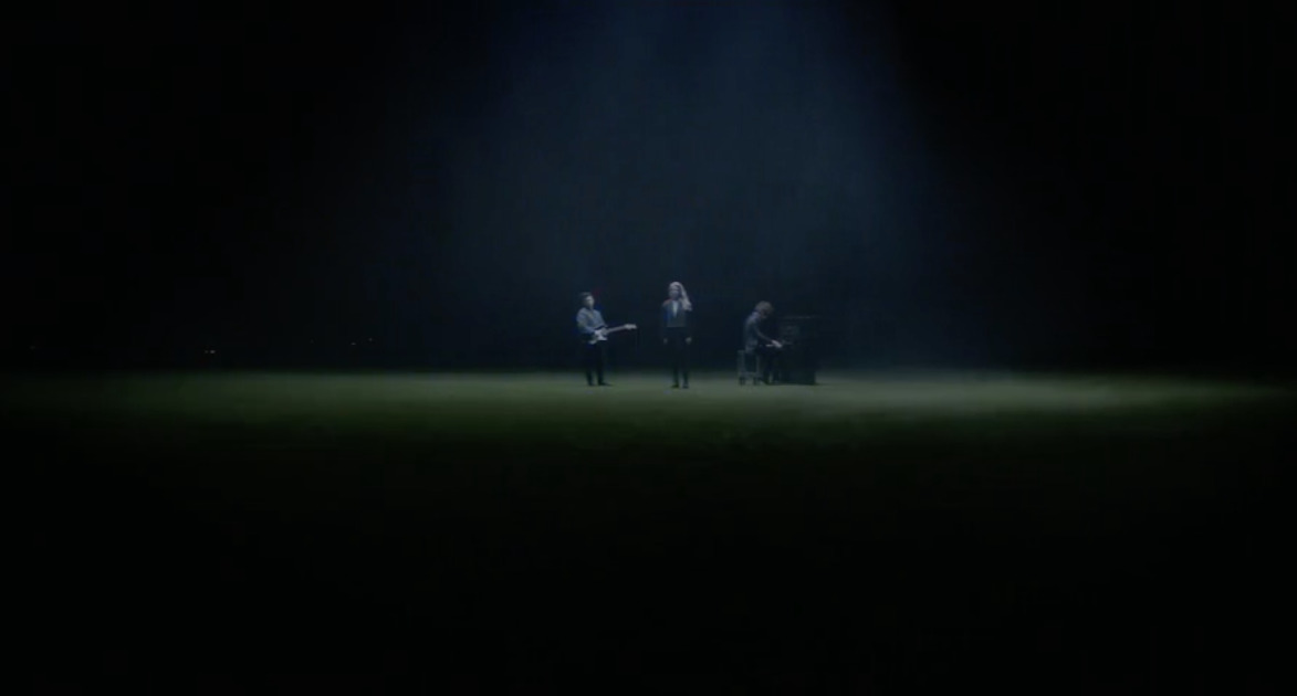 a group of people standing on top of a lush green field