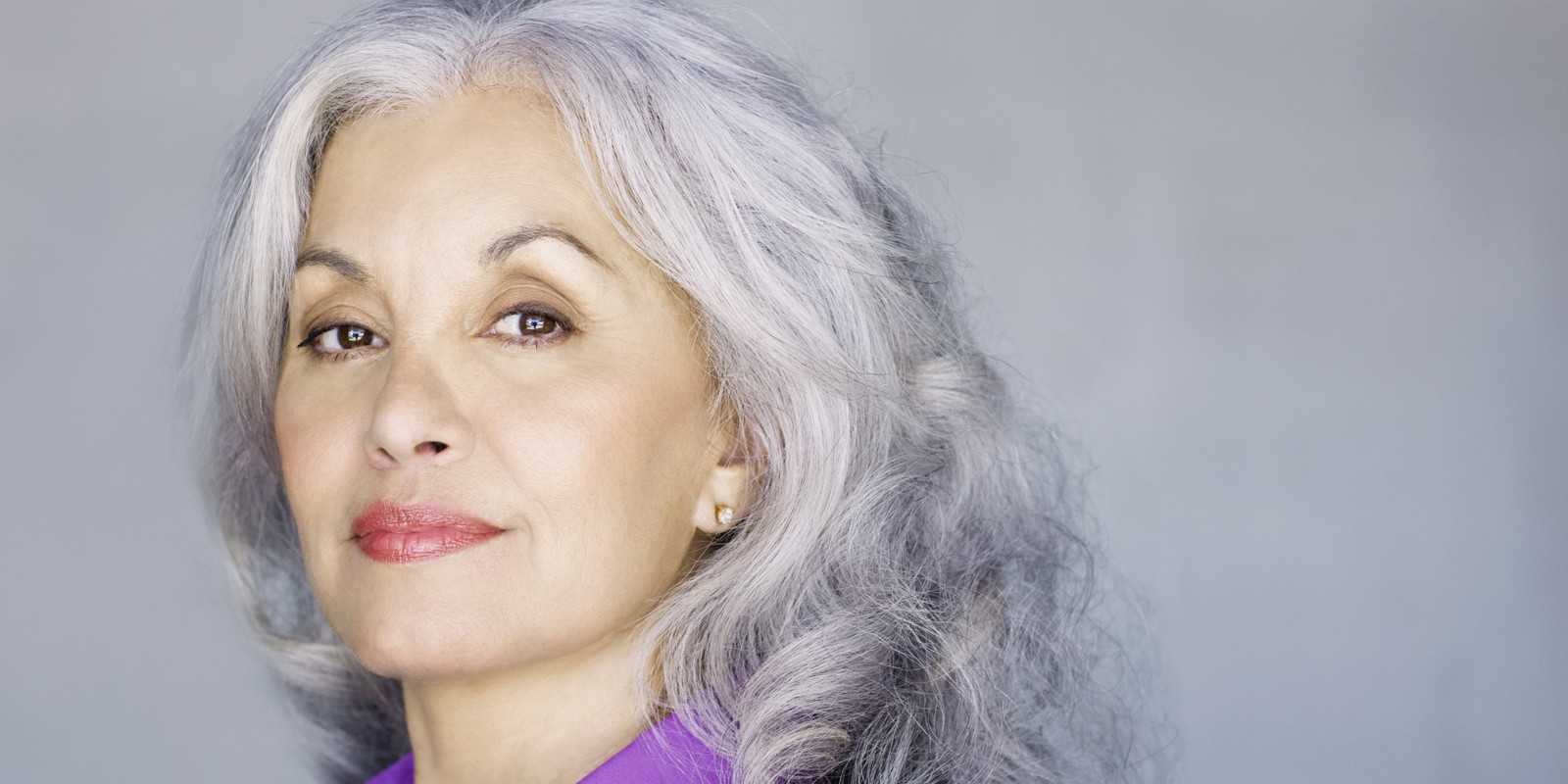 a woman with grey hair and a purple shirt