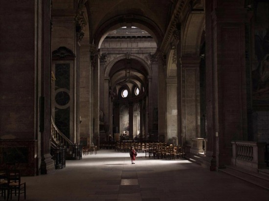 a person standing in a large building with a clock on the wall