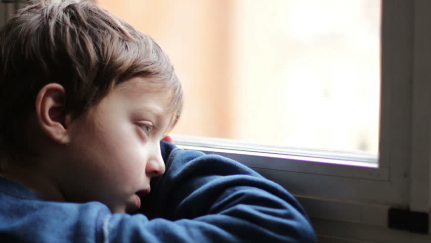 a young boy looking out of a window