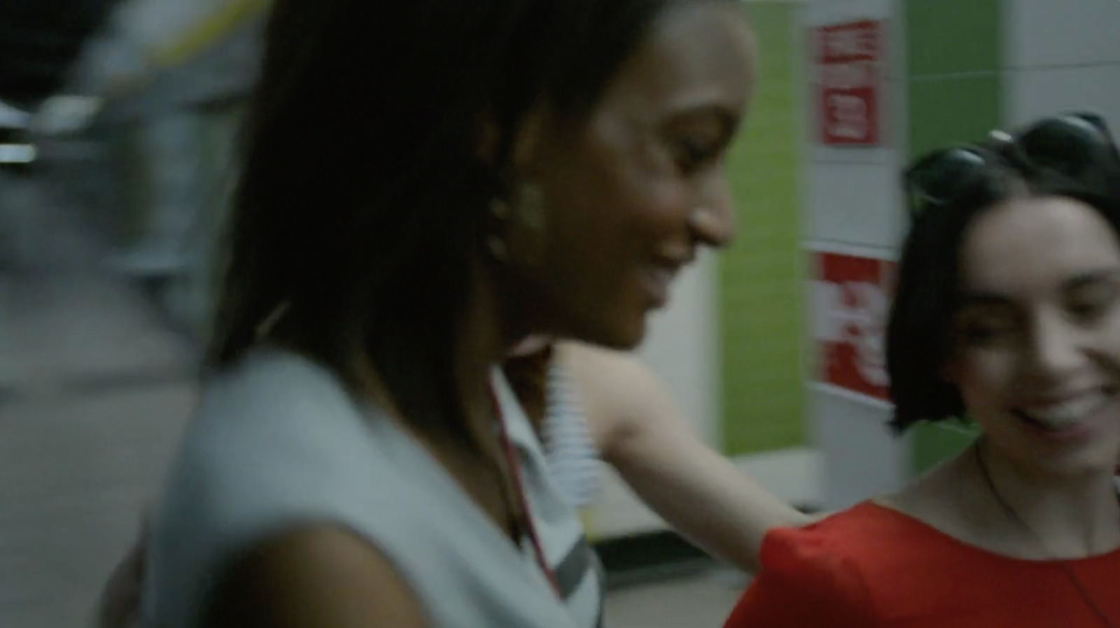 a woman in a red dress standing next to another woman