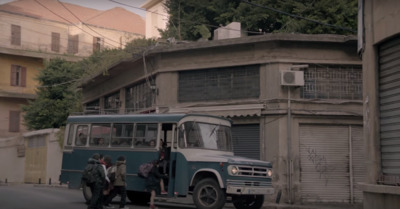 a bus parked on the side of a road next to a building